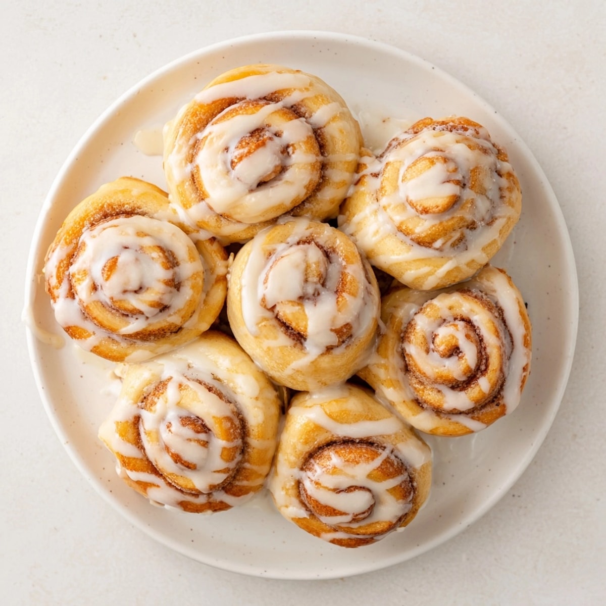 Golden brown Cinnamon Roll Bites, fresh from the oven, topped with a sweet glaze.