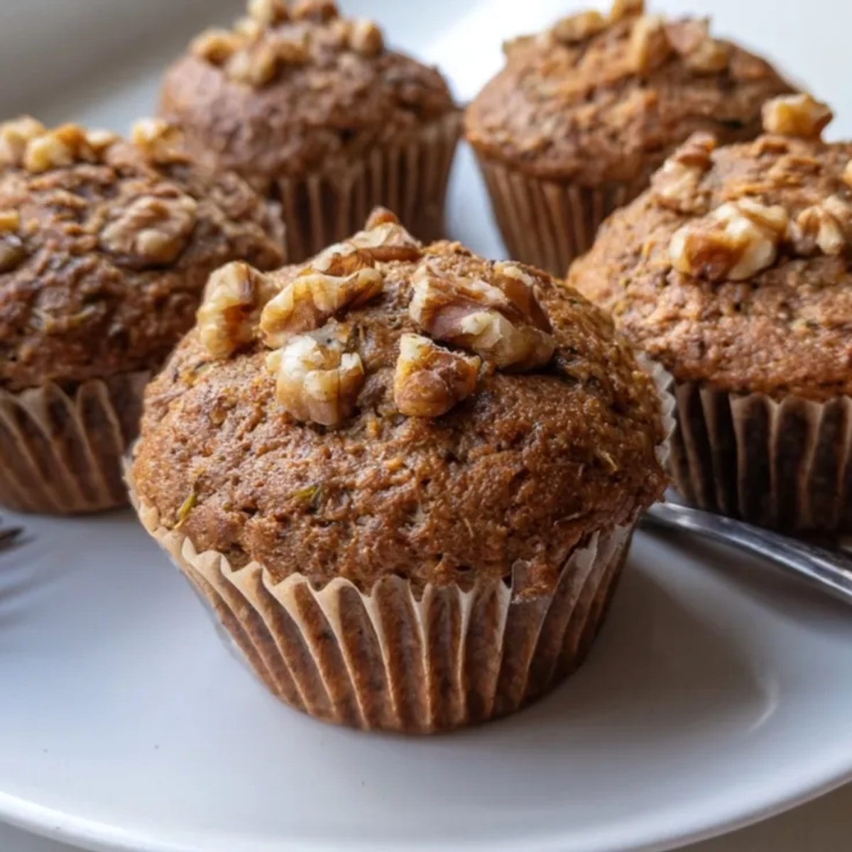 Golden Protein Cinnamon Zucchini Muffins on a cooling rack, smelling warmly of spice.