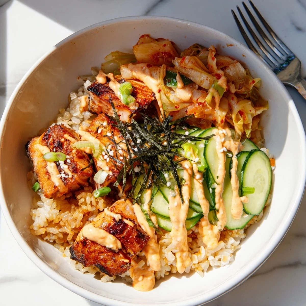 A colorful Crispy Salmon Rice Bowl featuring creamy avocado and zesty toppings.