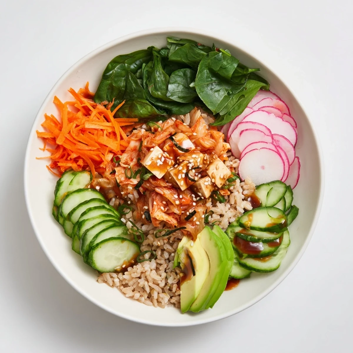 Colorful fermented vegetable bowl featuring kimchi, grains, and ripe avocado slices.  
