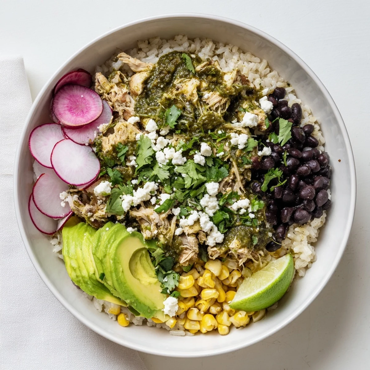 Vibrant Green Enchiladas Rice Bowl topped with fresh avocado and cilantro.  