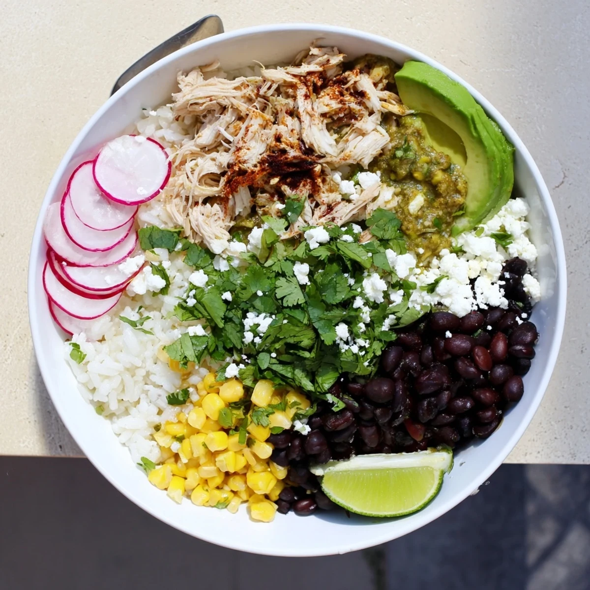 Hearty Green Enchiladas Rice Bowl with shredded chicken, black beans, and fluffy rice.