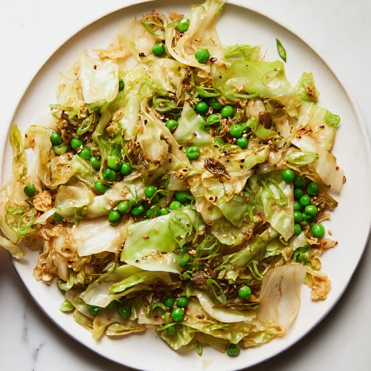 A colorful close-up of Cabbage Stir-Fry with garlic and peas, glistening with savory sauce for dinner.