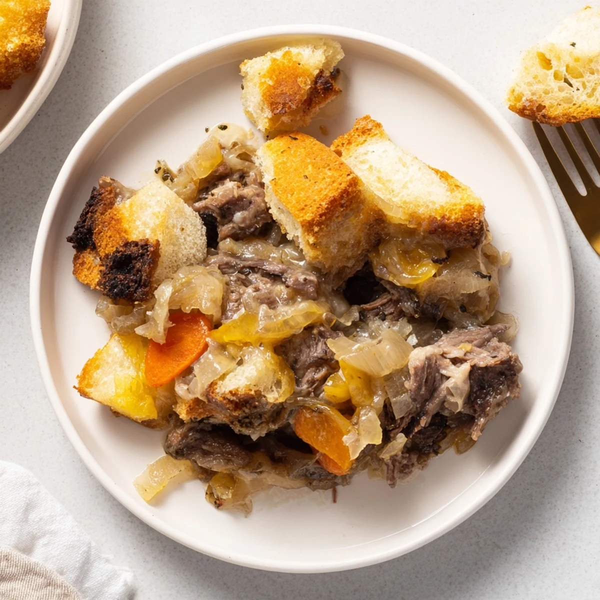 French Onion Pot Roast Casserole bubbling with melted cheese and crispy bread topping, a hearty family meal.