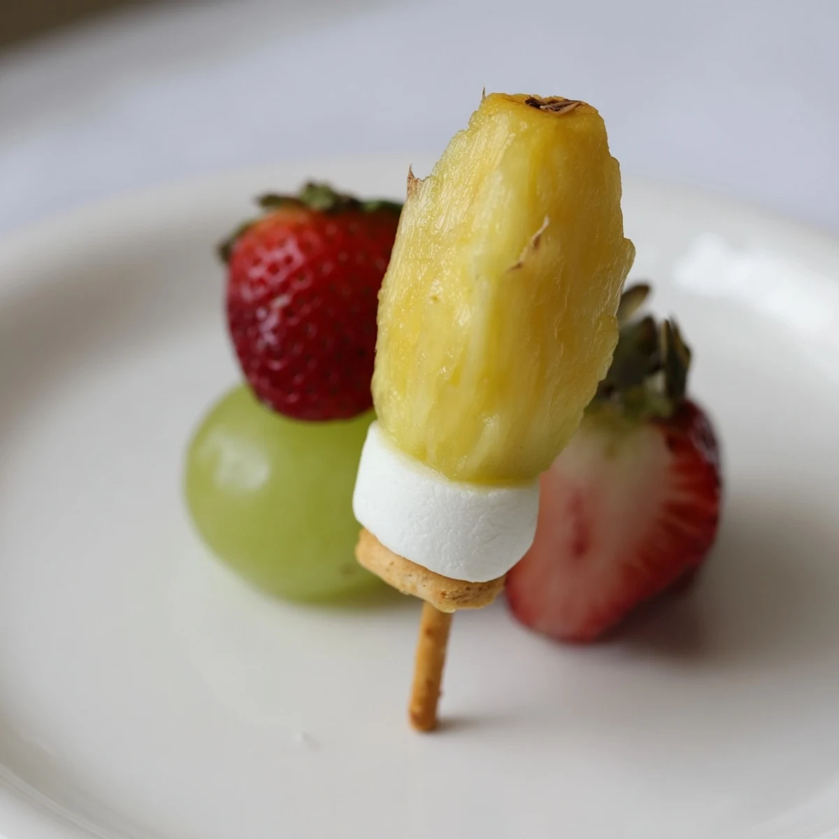 Vibrant Christmas Light fruit skewers featuring strawberries, grapes, and pineapple, arranged like festive lights.