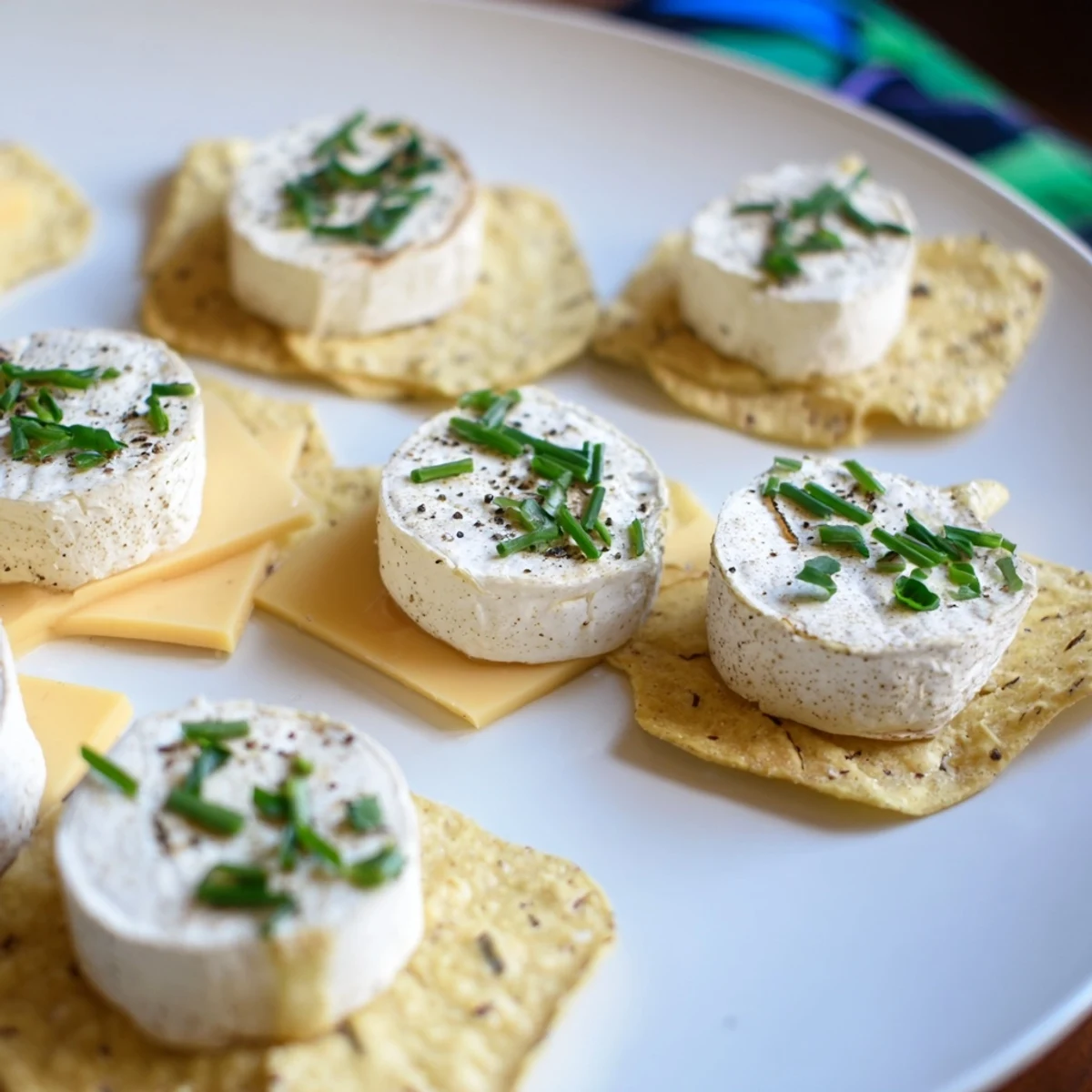 Appetizing The Stepping Stones appetizer showing cheese rounds like stepping stones over blue chips, ready to enjoy.