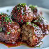 Grape Jelly and Chili Sauce Meatballs simmer in a sticky, glossy sauce inside a slow cooker, perfect for game day.