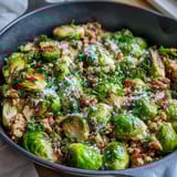 Bright lemon juice and melted Parmesan cheese garnish the hearty one-pan Brussels Sprouts & Ground Turkey Skillet meal, served steaming hot.