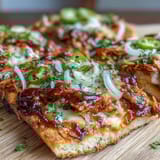 Sizzling BBQ chicken flatbread pizza loaded with red onions, bell peppers, and jalapeños for a spicy kick.  
