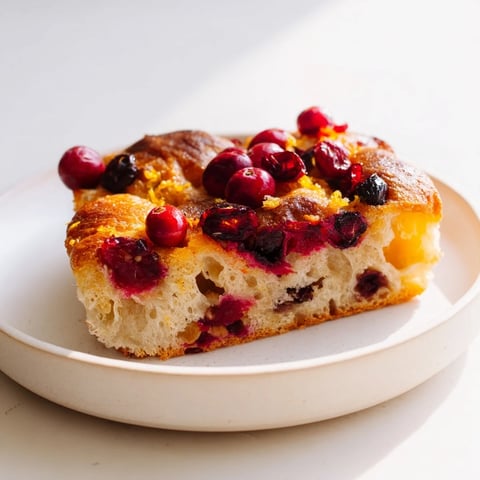 Golden-brown Cranberry Orange No-Knead Focaccia topped with bright cranberries and orange zest, ready to serve!