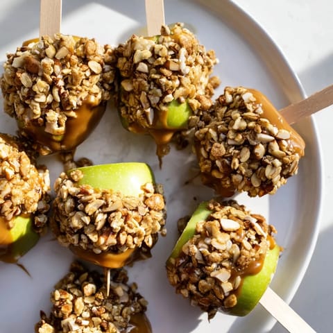 Crunchy caramel-coated apple pops rolled in granola, a perfect sweet snack treat.  