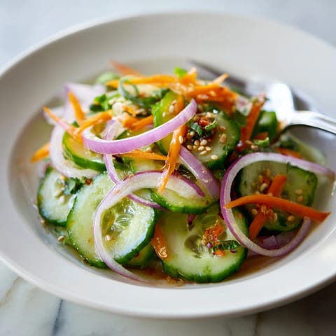 Colorful Cucumber Salad Remix drizzled with sesame oil, perfect for summer gatherings.  