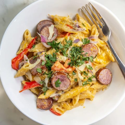 Golden-baked Smoked Sausage & Cheddar Pasta Bake with visible sausage and cheesy, creamy texture.
