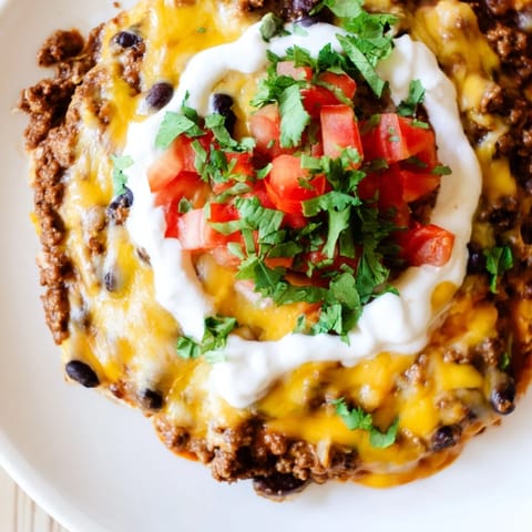 Close-up shot shows the creamy, bubbly Slow Cooker Cream Cheese Taco Dip garnished with fresh cilantro.