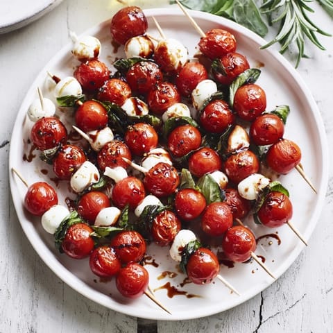 Holiday appetizer featuring Easy Christmas Tree Caprese Skewers, drizzled with balsamic glaze, ready to serve this season.