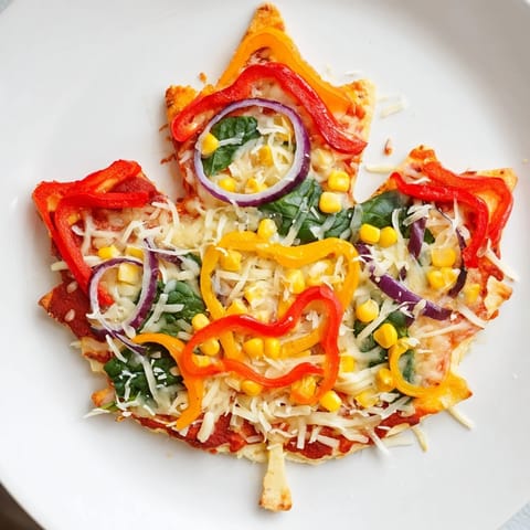Vibrant Fall Foliage Maple Leaf Mini Pizzas, topped with autumn vegetables and sweet maple syrup sauce.