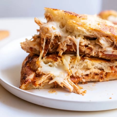 Savory and easy: warm Leftover Pizza Grilled Cheese with shredded chicken and crispy pizza crust.
