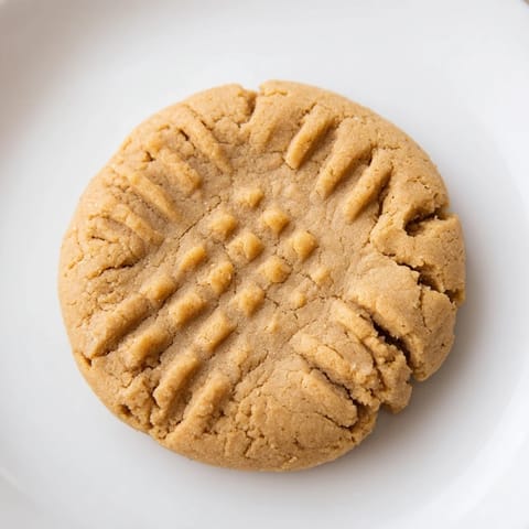 Freshly baked flourless peanut butter cookies arranged on a cooling rack, looking delicious.