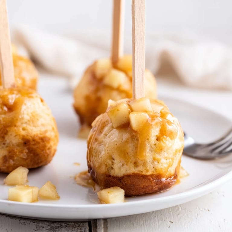 Savory and sweet Maple Bourbon Apple Cheddar Muffin Pops on a rustic wooden table.