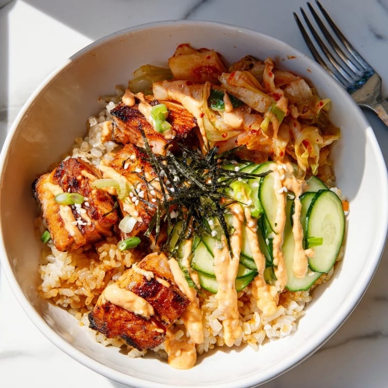 A colorful Crispy Salmon Rice Bowl featuring creamy avocado and zesty toppings.