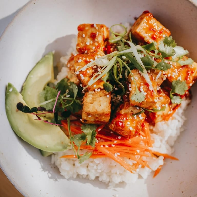 Golden, baked tofu pieces glistening with chili-mayo sauce atop a bed of rice in these bowls.