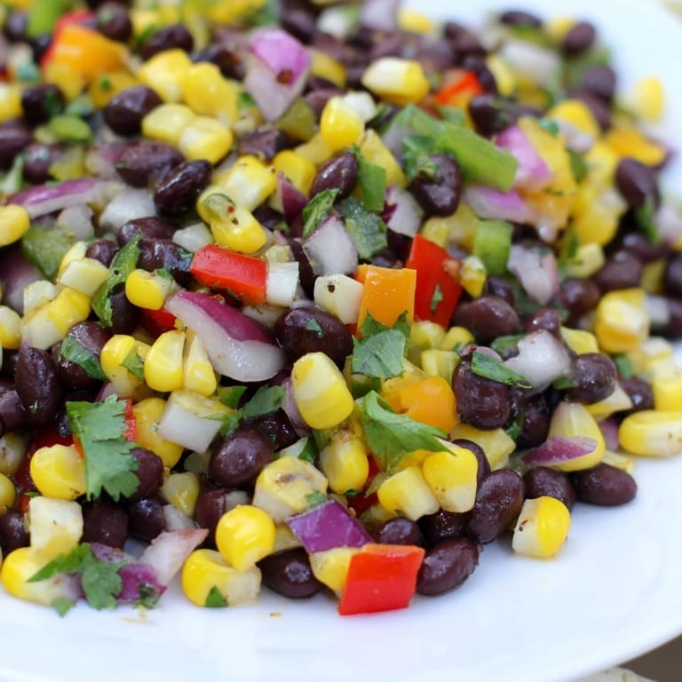 A close-up of a refreshing Cowboy Caviar Salad bowl, featuring colorful vegetables and black beans.