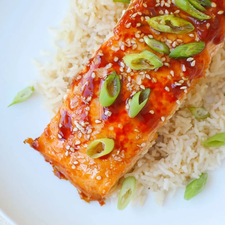 A close-up of perfectly broiled Sticky Orange Salmon, with caramelized edges and a tangy glaze, ready to eat.