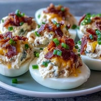 Jalapeño Popper Deviled Eggs with Cream Cheese: creamy, spicy filling topped with crispy bacon and fresh jalapeño slices.