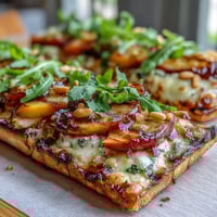 Grilled flatbread topped with sweet peaches, melted Brie, and smoky BBQ sauce for a summery treat.